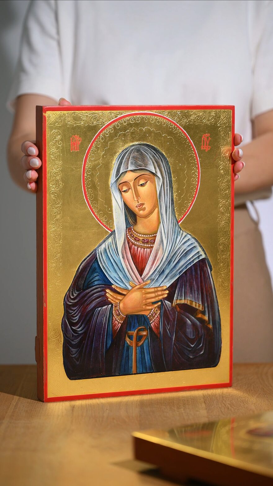 An icon held in the hands and turned towards the light